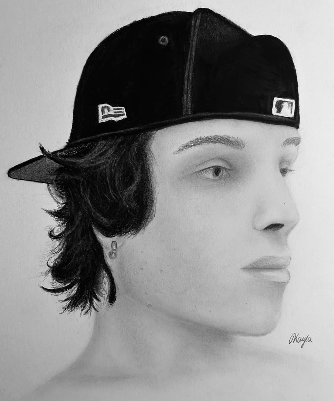 Graphite portrait of a young man wearing a backwards baseball cap.