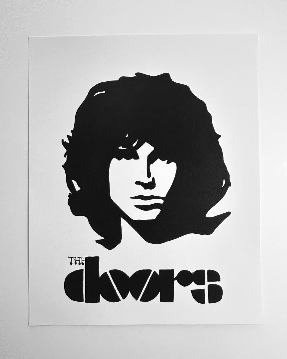 High-contrast black ink portrait of Jim Morrison above The Doors logo.